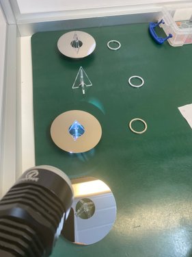 Hard drive platters and spacer rings on cleanroom mat with inspection light