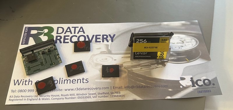 Lexar CFast card with removed NAND chips arranged on an R3 Data Recovery compliments slip