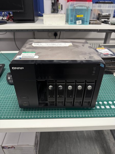 QNAP NAS enclosure with multiple front drive bays on an R3 bench prepared for enterprise RAID recovery