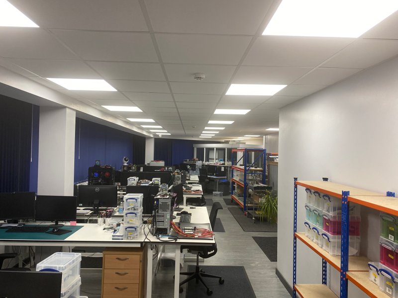 Wide view of R3 main lab with benches and shelving under bright lighting